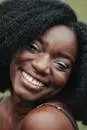 Happy adult African American female with perfect skin smiling while looking at camera